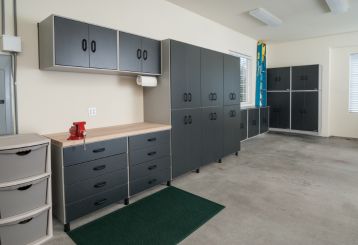Modern custom garage organization setup with dark cabinets and wooden workbench in Chandler, AZ