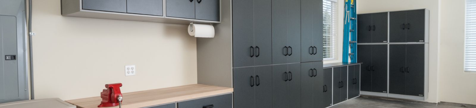 Modern custom garage organization setup with dark cabinets and wooden workbench in Chandler, AZ