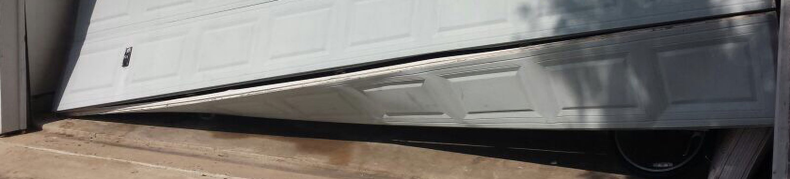 Severely off track white sectional panel garage door in Chandler, AZ needing urgent repair.